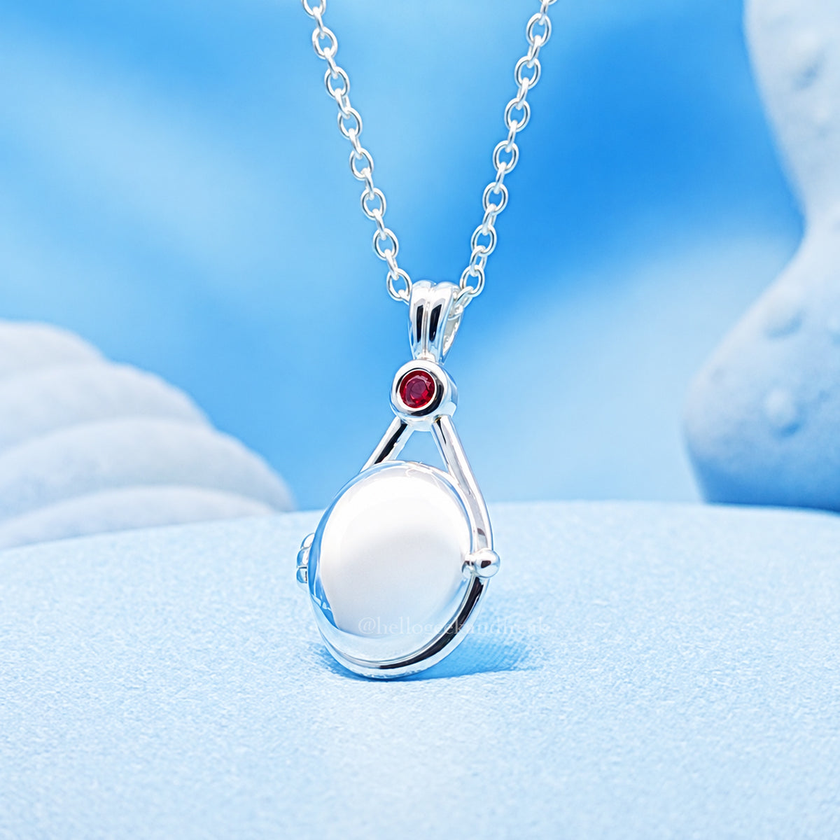 Colgante mini locket plateado con cadena y gema roja en el centro