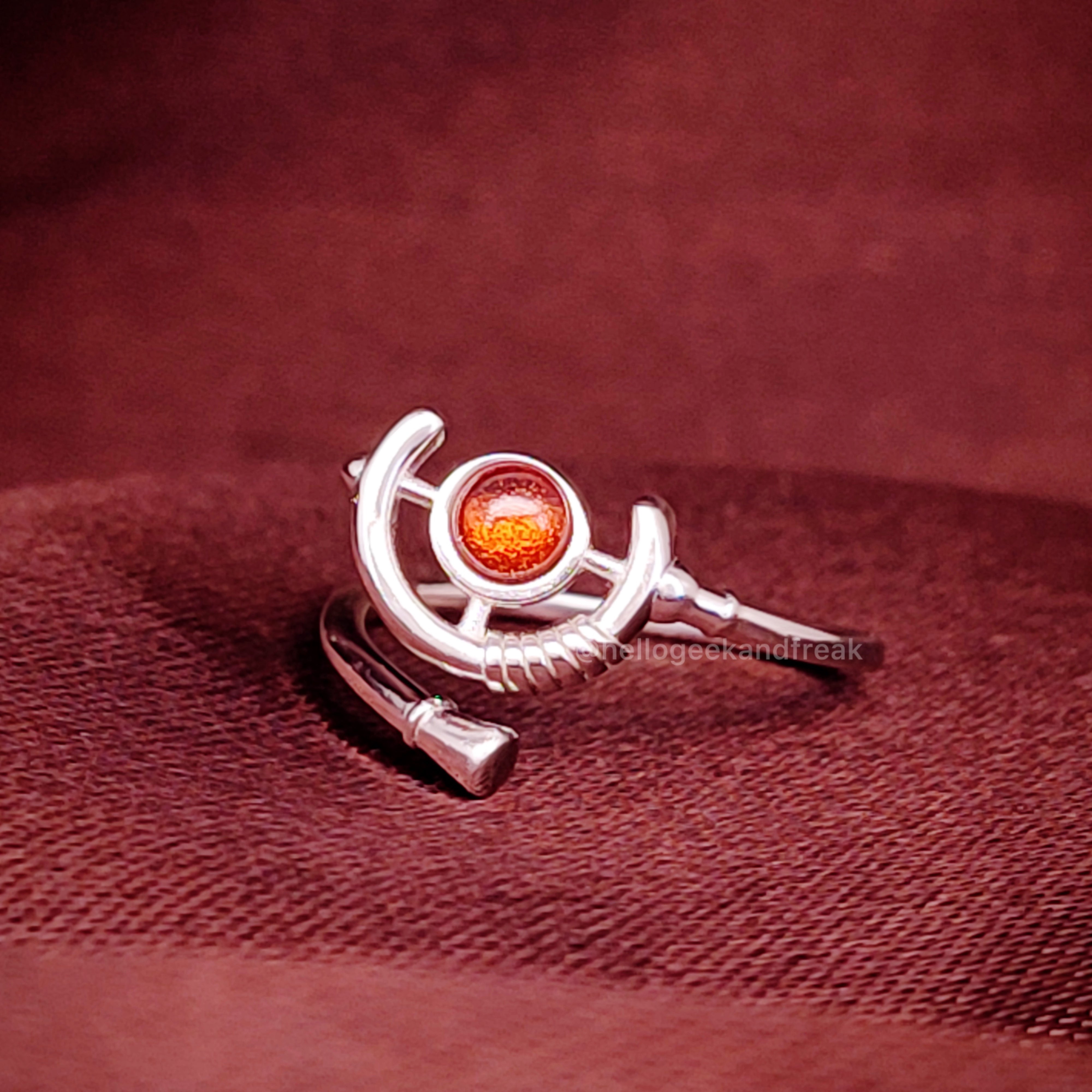Anillo plateado con piedra redonda ámbar y diseño curvo abierto