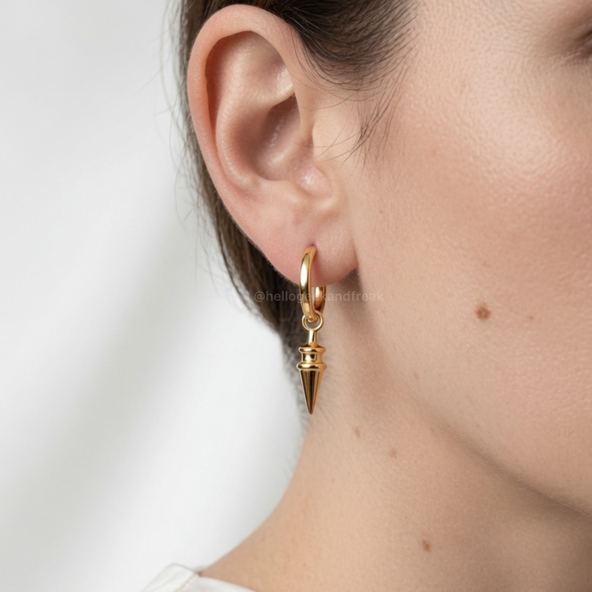 Pendientes dorados con aro y colgante puntiagudo cónico en la oreja