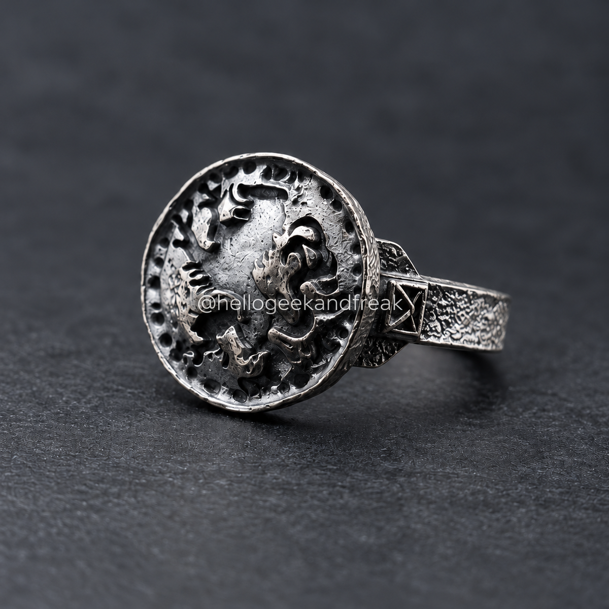 Anillo metálico con león grabado en relieve y banda ancha texturizada