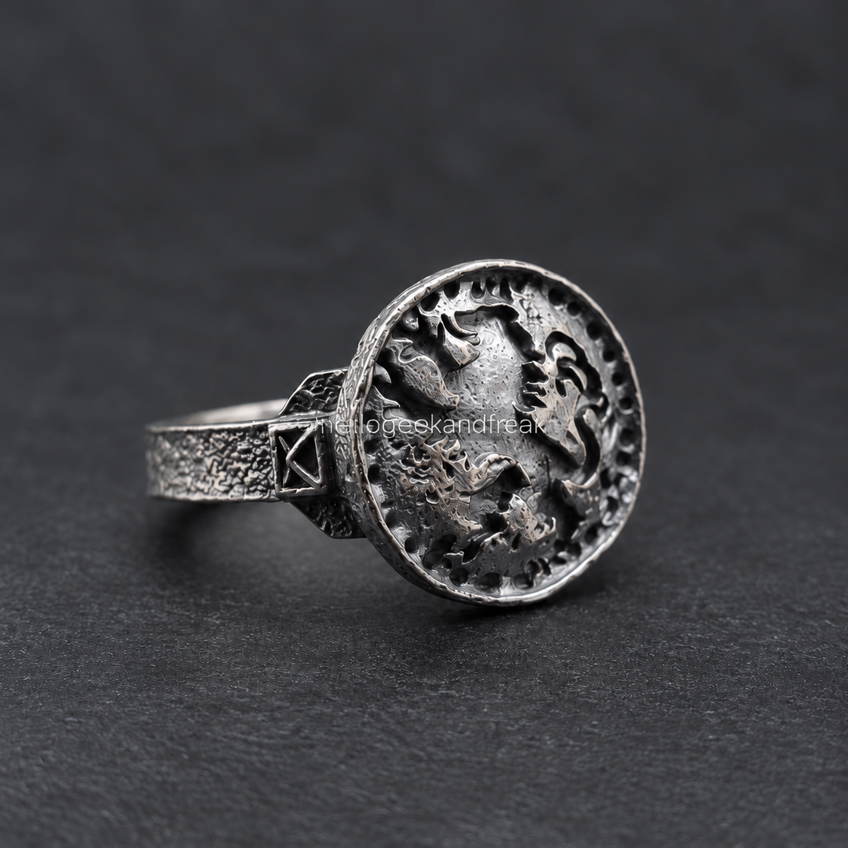 Anillo de metal con grabado de león en relieve y banda texturizada