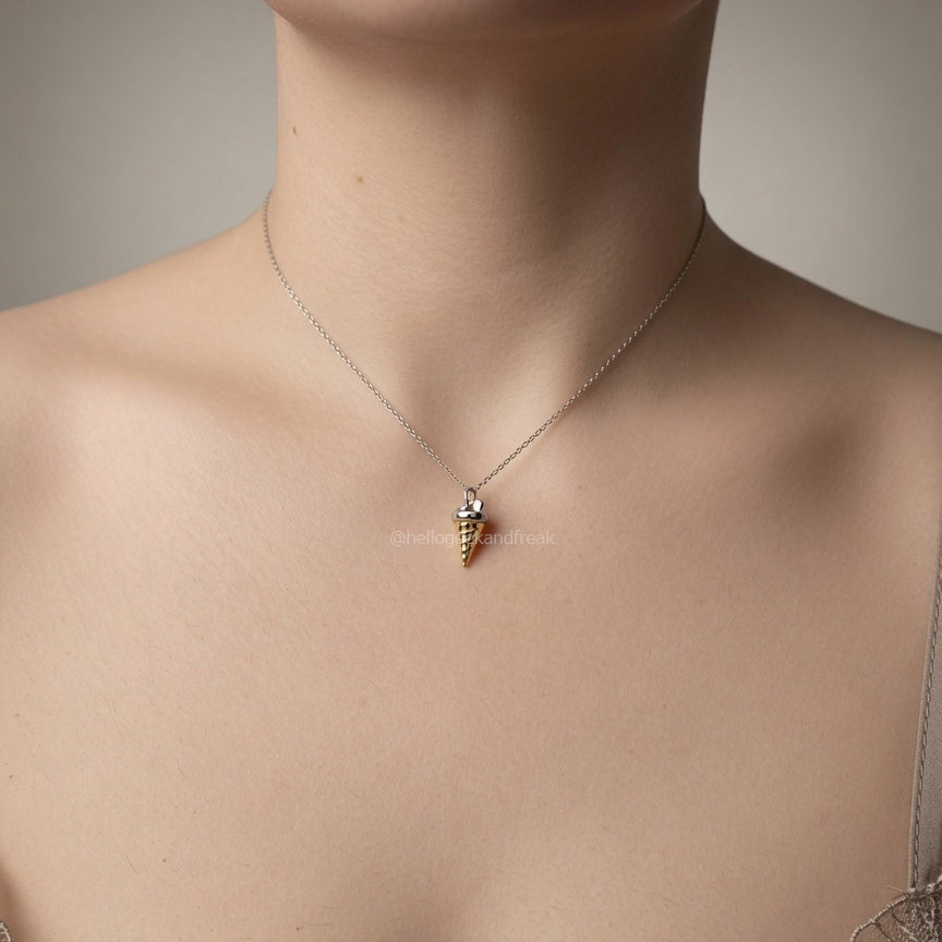 Colgante con cadena fina y dije metálico pequeño con detalle oscuro