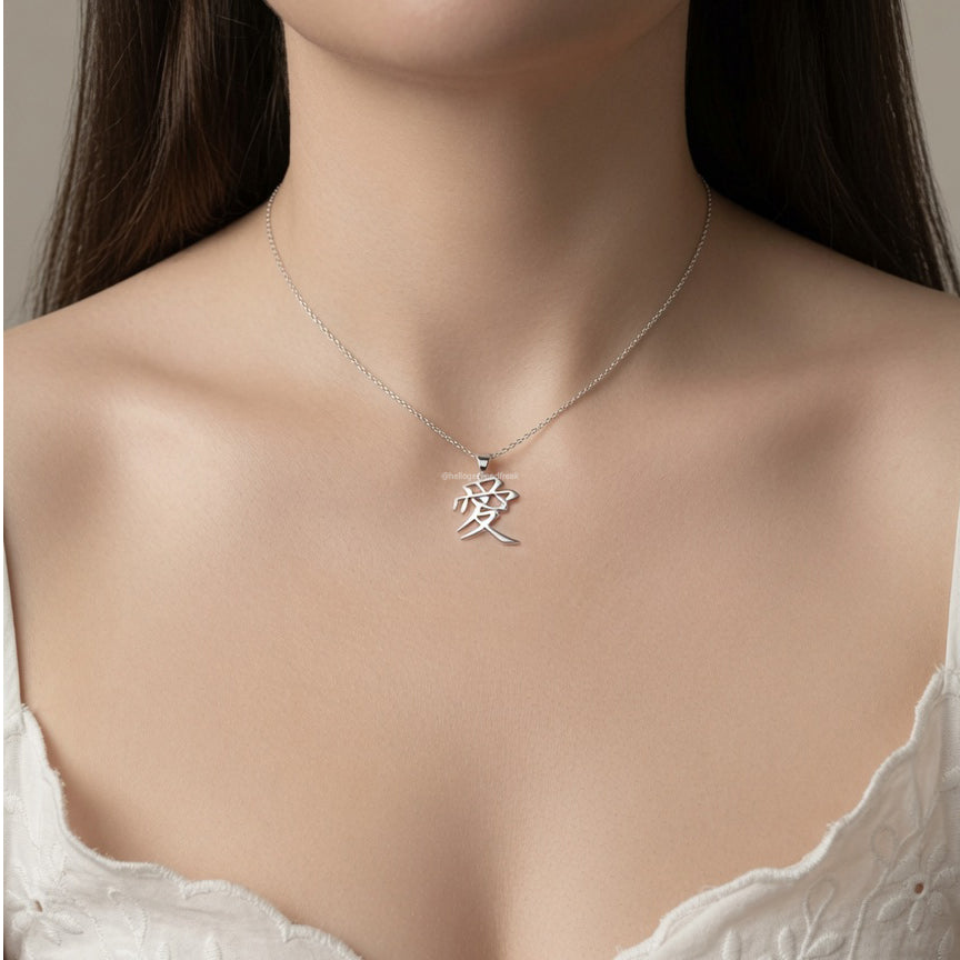 Colgante de plata con cadena fina y dije kanji sobre el pecho