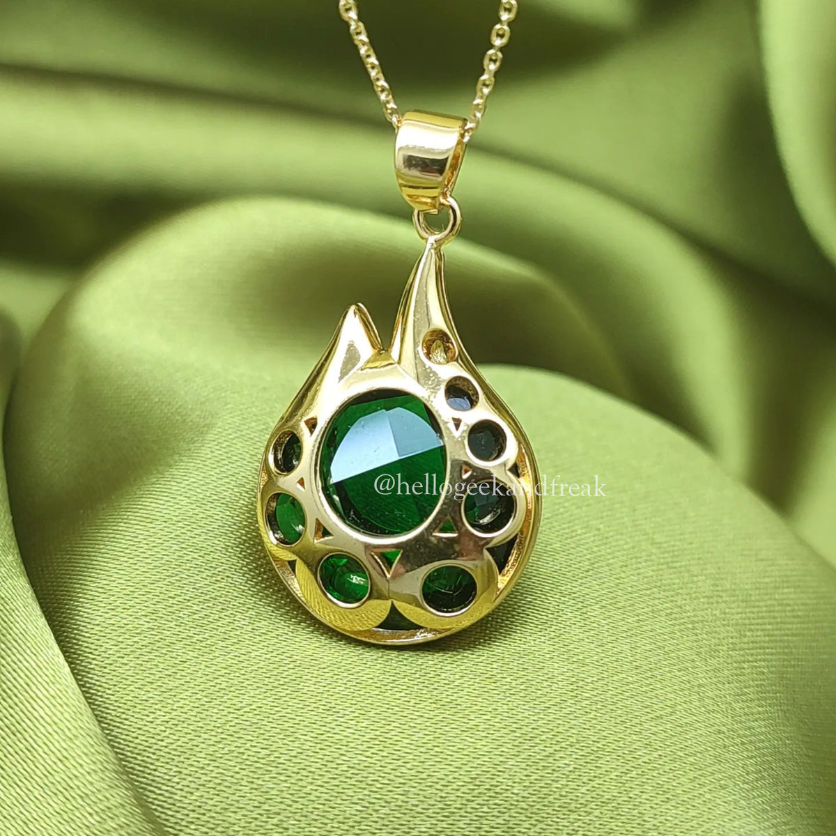 Colgante Estamina chapado en oro con lágrima calada y piedras verdes, cadena